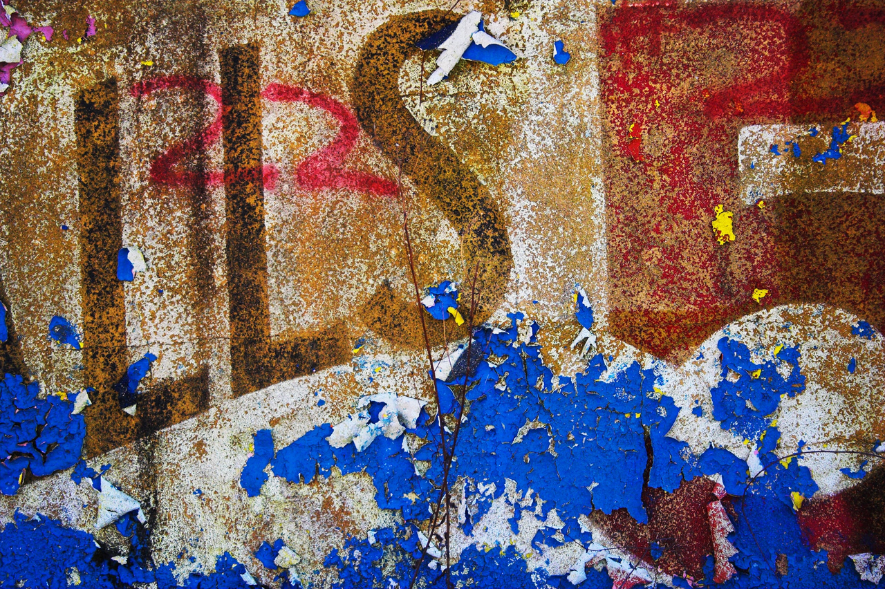 You Must Be This Tall project: peeling blue paint and faded red lettering on a textured wall.